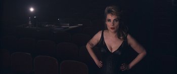 Movie still from “Venus in Fur” (2013), directed by Roman Polanski – A woman standing in a theater with her hands on her hips; Medium shot, High angle