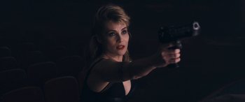 Movie still from “Venus in Fur” (2013), directed by Roman Polanski – A woman holding a gun in a dark room; Close Up shot, Over the shoulder angle