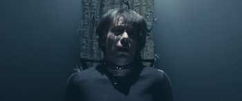 Movie still from “Venus in Fur” (2013), directed by Roman Polanski – A man in a black shirt and a black collar; Close Up shot, High angle