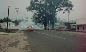 Movie still from “Vernon, Florida” (1981), directed by Errol Morris – An old truck is driving down the street; Extreme Wide shot, High angle
