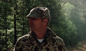 Movie still from “Vernon, Florida” (1981), directed by Errol Morris – A man wearing a camouflage jacket and hat; Close Up shot, Low angle