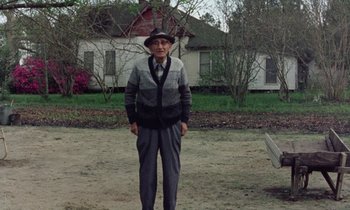 Movie still from “Vernon, Florida” (1981), directed by Errol Morris – An old man standing in front of a house; Wide shot, Low angle