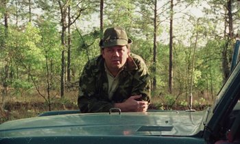 Movie still from “Vernon, Florida” (1981), directed by Errol Morris – A man leaning on the hood of a truck; Medium shot, Low angle