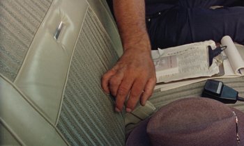Movie still from “Vernon, Florida” (1981), directed by Errol Morris – A man's hand on the back of a car seat; Extreme Close Up shot, Overhead angle