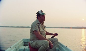 Movie still from “Vernon, Florida” (1981), directed by Errol Morris – A man sitting in a boat on the water; Medium shot, Low angle