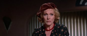 Movie still from “Victor/Victoria” (1982), directed by Blake Edwards – An older woman wearing a hat and a red necklace; Close Up shot, Over the shoulder angle