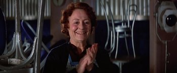 Movie still from “Victor/Victoria” (1982), directed by Blake Edwards – An older woman clapping her hands while wearing an apron; Close Up shot, Low angle