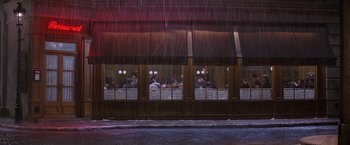 Movie still from “Victor/Victoria” (1982), directed by Blake Edwards – A group of diners sitting at a restaurant in the pouring rain; Extreme Wide shot, High angle