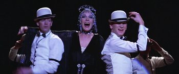 Movie still from “Victor/Victoria” (1982), directed by Blake Edwards – A group of men and a woman performing a dance; Medium shot, Low angle