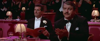 Movie still from “Victor/Victoria” (1982), directed by Blake Edwards – Two men in tuxedos sitting at a table; Medium shot, Low angle