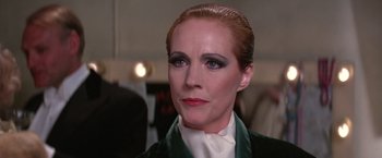 Movie still from “Victor/Victoria” (1982), directed by Blake Edwards – A person wearing a suit and tie; Close Up shot, Over the shoulder angle