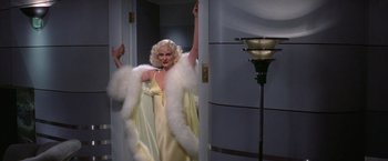 Movie still from “Victor/Victoria” (1982), directed by Blake Edwards – A woman dressed in a yellow dress and a white fur coat; Medium shot, Low angle