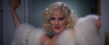 Movie still from “Victor/Victoria” (1982), directed by Blake Edwards – A woman with blonde hair and red lipstick; Close Up shot, Low angle