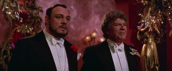 Movie still from “Victor/Victoria” (1982), directed by Blake Edwards – Two men in tuxedos standing next to each other; Medium shot, Low angle