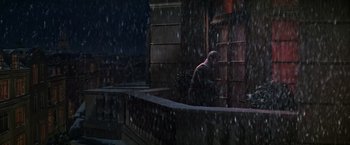 Movie still from “Victor/Victoria” (1982), directed by Blake Edwards – A man standing in the rain next to a building; Extreme Wide shot, High angle