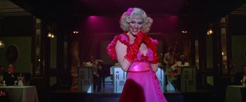 Movie still from “Victor/Victoria” (1982), directed by Blake Edwards – A woman in a pink and red dress on a stage; Medium shot, Low angle