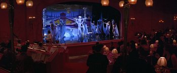 Movie still from “Victor/Victoria” (1982), directed by Blake Edwards – A group of people are performing on a stage in a theater; Wide shot, High angle