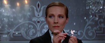 Movie still from “Victor/Victoria” (1982), directed by Blake Edwards – A woman holding a lit cigarette in her hand; Close Up shot, Low angle