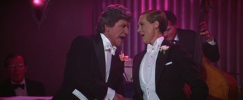 Movie still from “Victor/Victoria” (1982), directed by Blake Edwards – A man and a woman in tuxedos talking to each other; Medium shot, Low angle