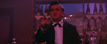 Movie still from “Victor/Victoria” (1982), directed by Blake Edwards – A man in a suit and bow tie pointing at something; Close Up shot, Low angle