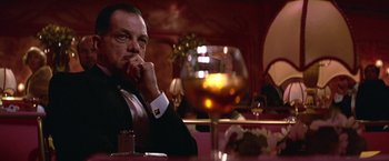 Movie still from “Victor/Victoria” (1982), directed by Blake Edwards – A man sitting at a table with a glass of wine in front of him; Close Up shot, Low angle