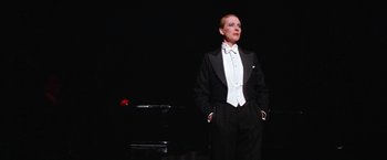 Movie still from “Victor/Victoria” (1982), directed by Blake Edwards – A man in a tuxedo standing in front of a piano; Medium shot, Low angle