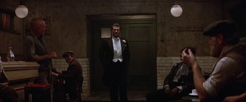 Movie still from “Victor/Victoria” (1982), directed by Blake Edwards – A man in a tuxedo standing in front of a door way; Wide shot, Low angle