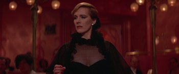 Movie still from “Victor/Victoria” (1982), directed by Blake Edwards – A woman in a black dress is standing in a room; Close Up shot, Low angle
