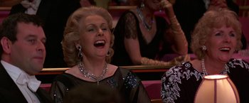 Movie still from “Victor/Victoria” (1982), directed by Blake Edwards – An older woman in a black dress laughing; Close Up shot, Low angle