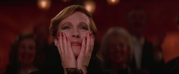 Movie still from “Victor/Victoria” (1982), directed by Blake Edwards – A person holding their hands up to their face; Close Up shot, Low angle