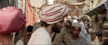 Movie still from “Victoria & Abdul” (2017), directed by Stephen Frears – A man with a turban is standing in a crowd of people; Medium shot, Over the shoulder angle