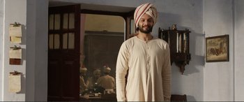 Movie still from “Victoria & Abdul” (2017), directed by Stephen Frears – A man wearing a turban standing in front of a mirror; Medium shot, Low angle