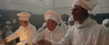 Movie still from “Victoria & Abdul” (2017), directed by Stephen Frears – A group of people wearing white hats and white aprons in a room; Medium shot, Low angle