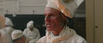 Movie still from “Victoria & Abdul” (2017), directed by Stephen Frears – A man in a chef's outfit with a frowning look on his face; Close Up shot, Low angle