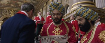 Movie still from “Victoria & Abdul” (2017), directed by Stephen Frears – A man in a turban is holding a silver tray; Medium shot, Over the shoulder angle