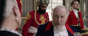 Movie still from “Victoria & Abdul” (2017), directed by Stephen Frears – A man with a beard wearing a turban and wearing a suit; Close Up shot, Over the shoulder angle