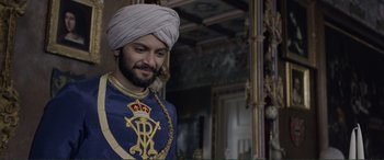 Movie still from “Victoria & Abdul” (2017), directed by Stephen Frears – A man wearing a turban and a blue and gold outfit; Medium shot, Over the shoulder angle