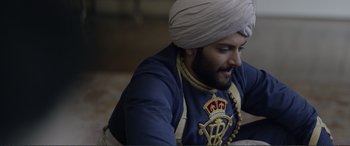 Movie still from “Victoria & Abdul” (2017), directed by Stephen Frears – A man wearing a turban and a blue shirt; Medium shot, Over the shoulder angle