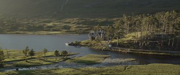 Movie still from “Victoria & Abdul” (2017), directed by Stephen Frears – A house on the side of a lake surrounded by trees and grass; Extreme Wide shot, High angle