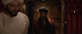 Movie still from “Victoria & Abdul” (2017), directed by Stephen Frears – A bearded man in a hat looking into a mirror; Medium shot, Over the shoulder angle