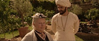 Movie still from “Victoria & Abdul” (2017), directed by Stephen Frears – An older woman and a younger man in a garden; Medium shot, Over the shoulder angle