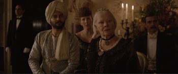 Movie still from “Victoria & Abdul” (2017), directed by Stephen Frears – A group of three people standing next to each other; Medium shot, Over the shoulder angle