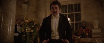 Movie still from “Victoria & Abdul” (2017), directed by Stephen Frears – An old man in a suit and a white bow tie; Medium shot, Low angle