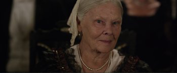 Movie still from “Victoria & Abdul” (2017), directed by Stephen Frears – An older woman wearing a head scarf and pearls; Close Up shot, Over the shoulder angle