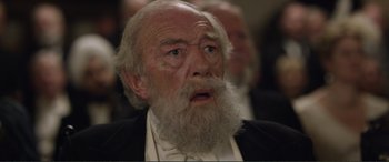 Movie still from “Victoria & Abdul” (2017), directed by Stephen Frears – An old man with a beard and a white mustache; Close Up shot, Over the shoulder angle