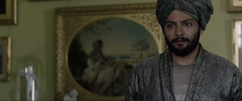 Movie still from “Victoria & Abdul” (2017), directed by Stephen Frears – A man with a turban standing in front of a painting; Close Up shot, Over the shoulder angle