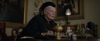 Movie still from “Victoria & Abdul” (2017), directed by Stephen Frears – An older woman sitting at a table with a cake; Close Up shot, High angle