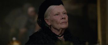 Movie still from “Victoria & Abdul” (2017), directed by Stephen Frears – An older woman wearing a black hat and a black jacket; Close Up shot, Over the shoulder angle