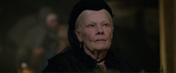 Movie still from “Victoria & Abdul” (2017), directed by Stephen Frears – An older woman wearing a black hat and a black dress; Close Up shot, Over the shoulder angle