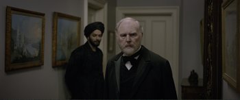 Movie still from “Victoria & Abdul” (2017), directed by Stephen Frears – A man in a black suit and a man in a black turban; Medium shot, Over the shoulder angle